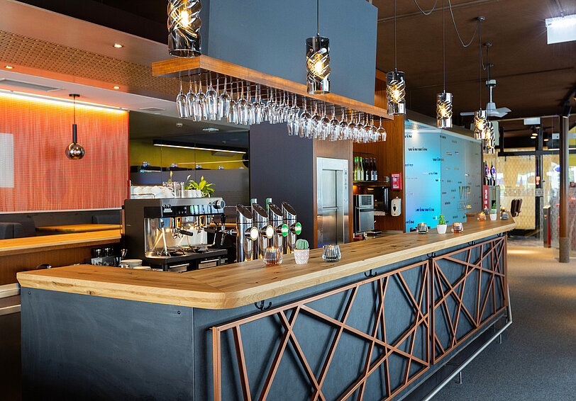 ©feelimage|Matern Designer-Bar mit Massivholz-Theke und anthrazitfarbener Front mit Kupfer-Metall-Deko im WINWIN Lienz.