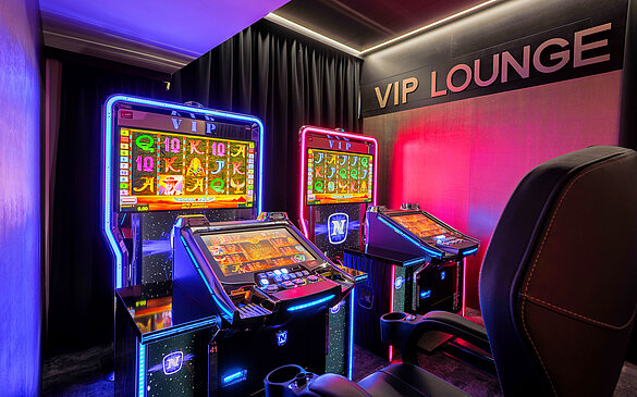 Zwei elegant beleuchtete VIP-Video Lottery Terminals im WINWIN Krems mit aktivem Spiel Book of Ra Deluxe.