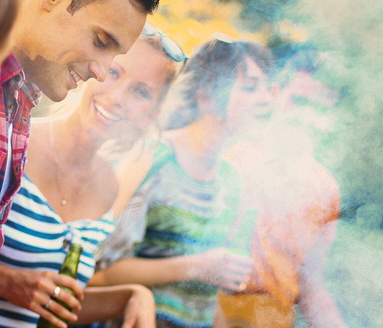 Eine Gruppe von fröhlichen Menschen grillt gemeinsam.