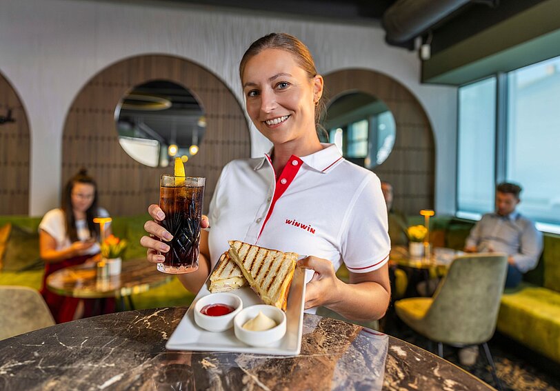WINWIN Mitarbeiterin präsentiert ein Gastronomie Angebot