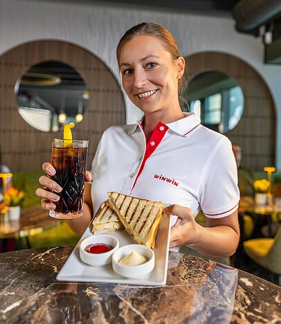 Eine WINWIN Mitarbeiterin präsentiert das Toast und Getränk Gastronomie Angebot