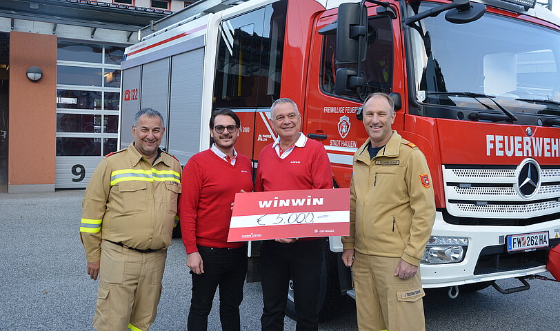 WINWIN Hallein Team ueberreicht Freiwillige Feuerwehr Hallein einen Spendenscheck. 