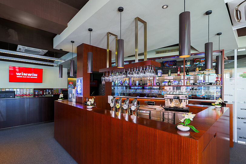 Die große Bar mit Mahagoni-Furnier und der Spielbereich-Check-In im WINWIN Krems.