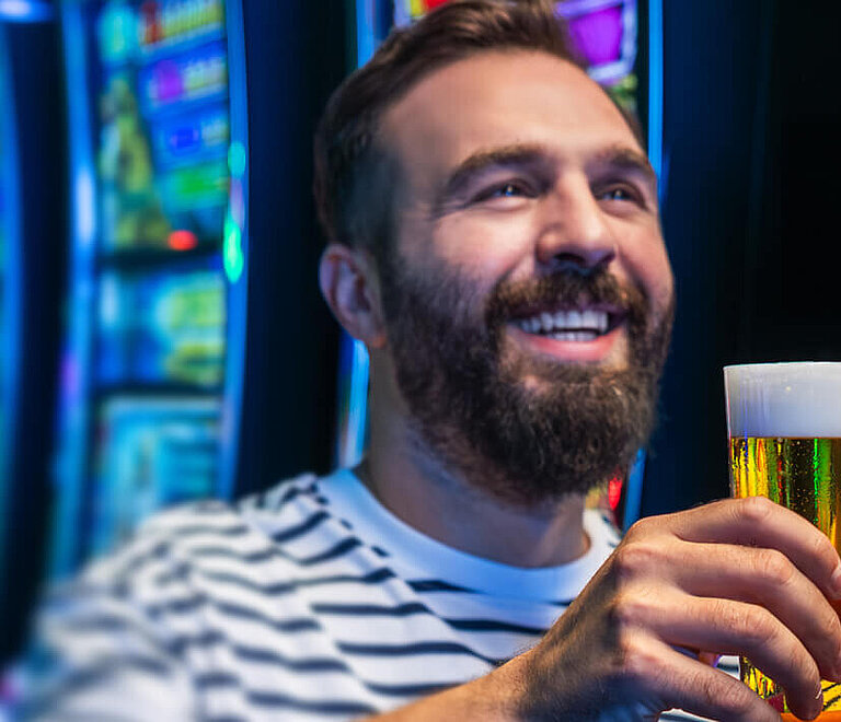 Ein Mann freut sich über das Getränk in seiner Hand.