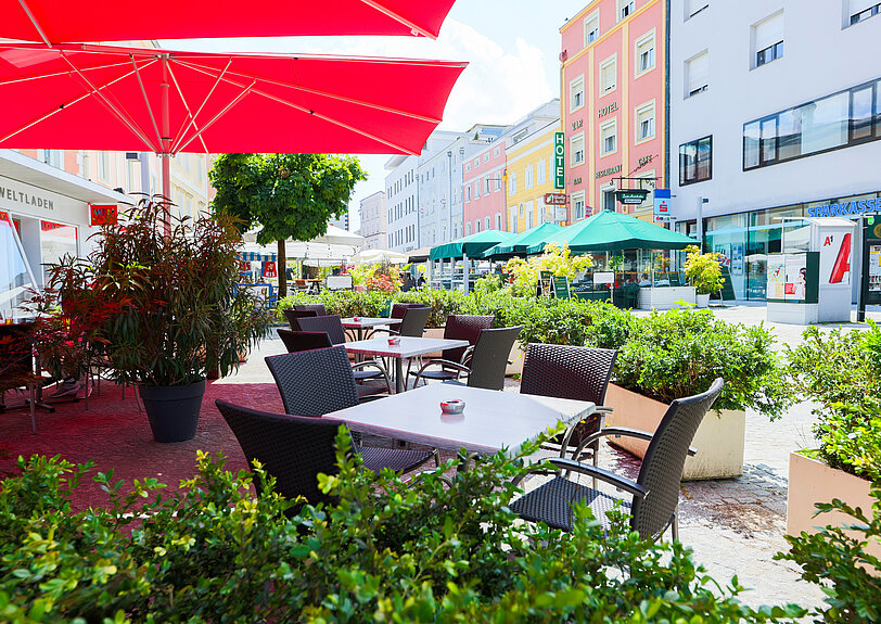 Der gemuetliche Gastgarten von WINWIN Voecklabruck mit zahlreichen gruenen Pflanzen.