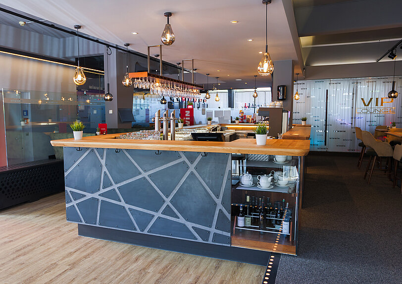 Modern gestaltete Bar im WINWIN Kufstein mit anthrazitfarbener Verkleidung und Massivholz-Theke. 