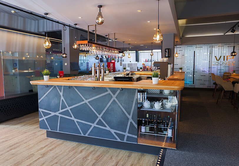 Modern gestaltete Bar im WINWIN Kufstein mit anthrazitfarbener Verkleidung und Massivholz-Theke. 