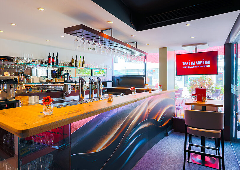Die Designer-Bar mit geschwungenem Design und Echtholz im WINWIN Voecklabruck.