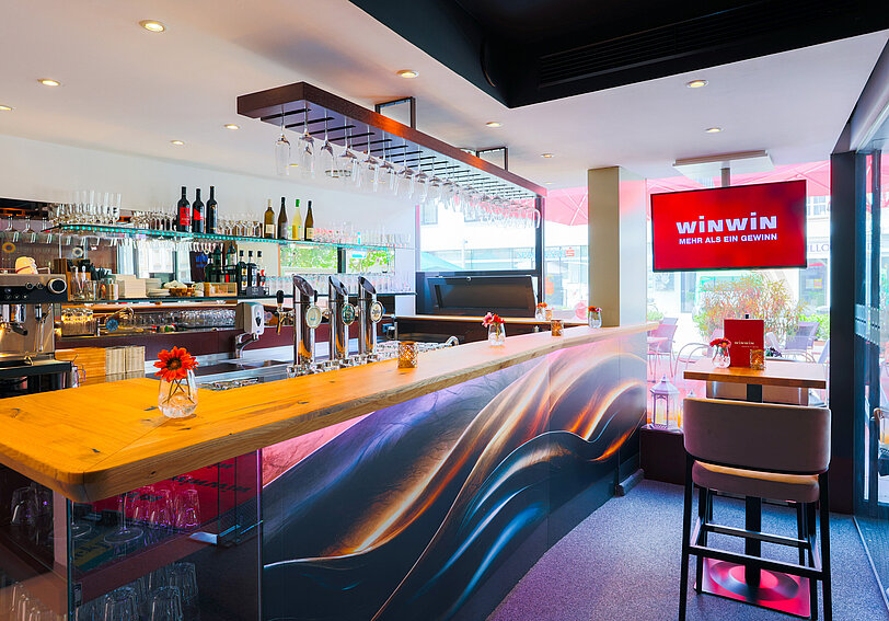 Die Designer-Bar mit geschwungenem Design und Echtholz im WINWIN Voecklabruck.