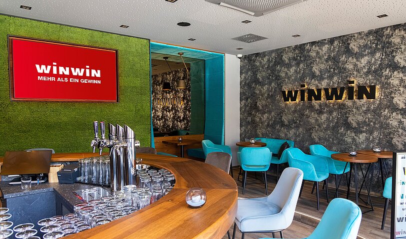 Gemuetliche Einrichtung im Lounge- und Barbereich mit verschiedenen Wanddekorationen im WINWIN Linz.