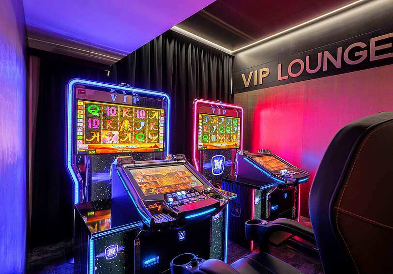 Zwei elegant beleuchtete VIP-Video Lottery Terminals im WINWIN Krems mit aktivem Spiel Book of Ra Deluxe.